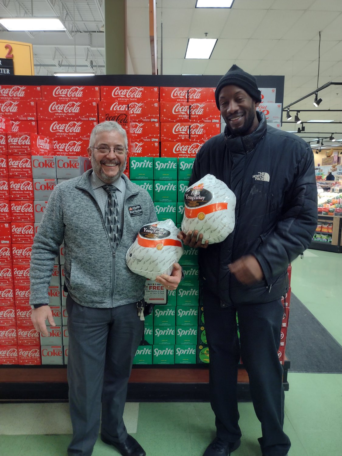 ShopRite manager Rich Hachan, left, and United Way CPO Julian Dawson hold two of the donated turkeys.